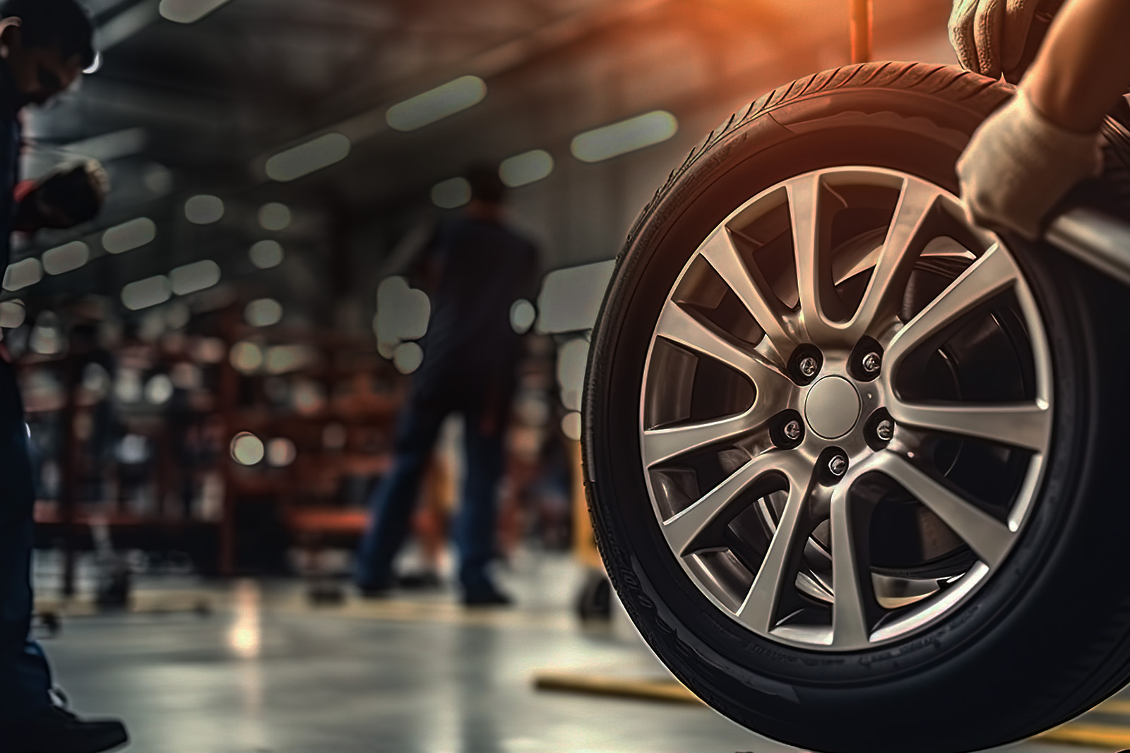 A tire being balanced on a wheel balancer machine in an industrial setting.